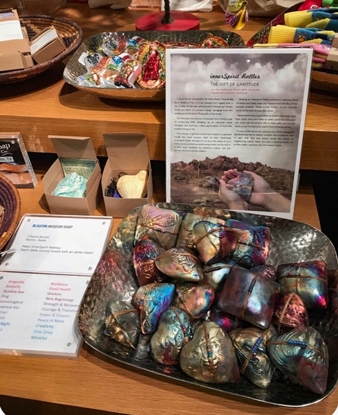 A display of innerSpirit Rattles in a large silver bowl next to "The Gift of Gratitude" story at The Jack S. Blanton Museum of Art at the University of Texas at Austin